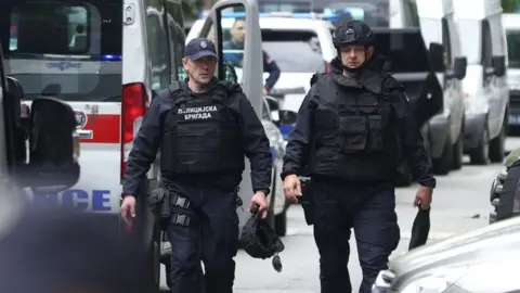 Police officers responding to the shooting in Belgrade