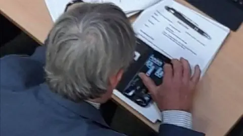 Val Haynes Councillor Charlie Dennis using his mobile phone