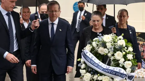 Israeli President Isaac Herzog walks in the rain wreath being laid at Bondi pavilion