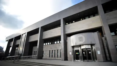 The entrance to the grey Glasgow Sheriff Court building which is at the top of some stairs