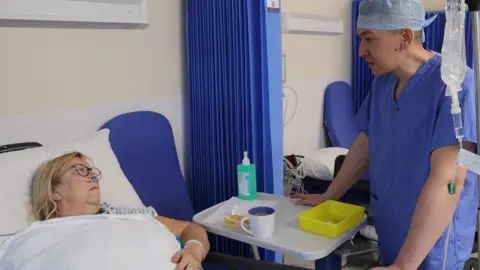 UHDB Janice sat in a hospital bed talking to doctor