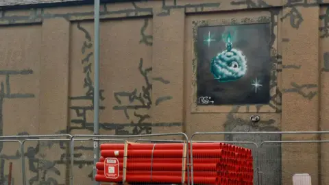 Psa The wall of a building, with graffiti over part of it 