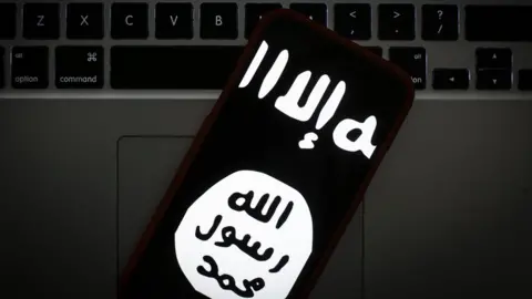 Getty Images The logo of the so-called Islamic State is seen on a mobile phone