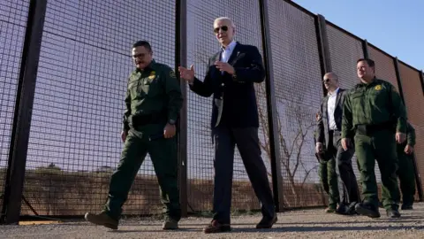 Reuters President Biden walks with border agents along a section of wall between the US and Mexico