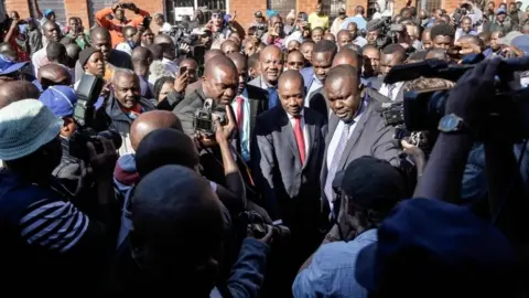 AFP Zimbabwe"s opposition leader Nelson Chamisa (C) arrives to cast his vote amid singing crowd at a polling station in Harare during Zimbabwe General Elections on July 30, 2018.