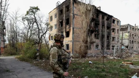 A Ukrainian soldier looks at destroyed buildings in Avdiivka, eastern Ukraine. File photo