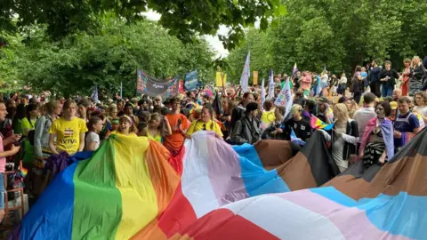 BBC Pride crowd holding a giant Pride flag