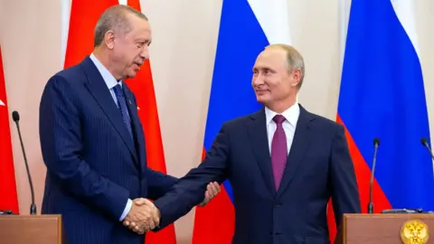 AFP Turkish President Recep Tayyip Erdogan shakes the hand of Russian President Vladimir Putin in Sochi (17 September 2018)