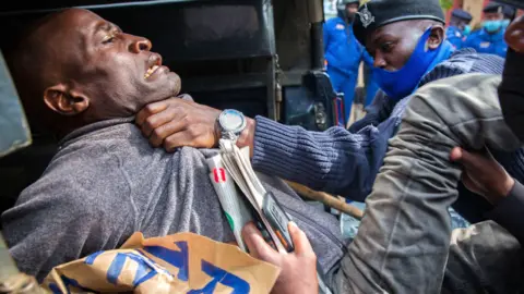 AFP A protester being manhandled by a police officer in Nairobi, Kenya - Saturday 1 May 2021