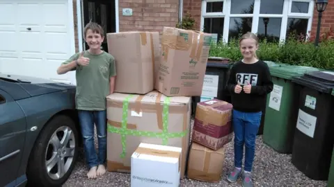 Kebrina Barker Stanley and Bridget Barker on their driveway with some boxes