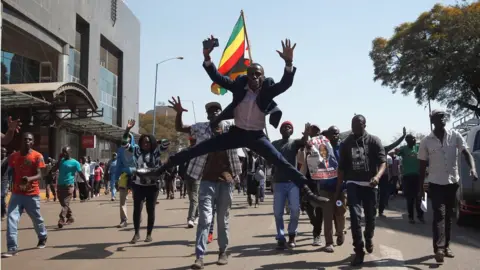 Reuters Supporters of the opposition Movement for Democratic Change party (MDC) of Nelson Chamisa, sing and dance as they march in the streets of Harare, 1 August 2018