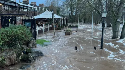The Mill on the Exe pub surrounded by flood water.