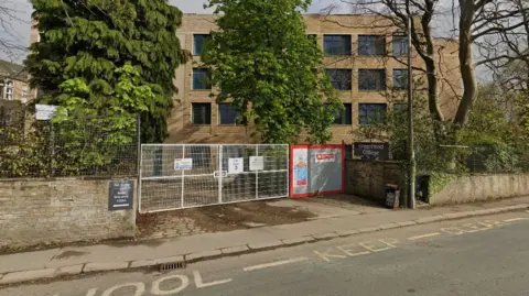 Greenhead sixth form college in Huddersfield.  It has a building site-style gate across the entrance. 