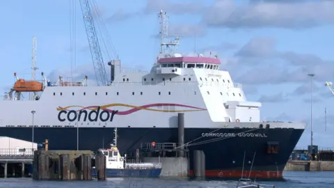 A large Condor Ferries boat stationed at the harbour on a cloudy day.