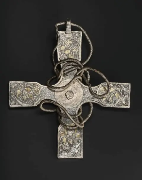 NMS A silver Anglo-Saxon cross on a black background.