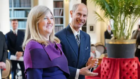 PA Media smiling woman with blonde hair next to a smiling balding man 