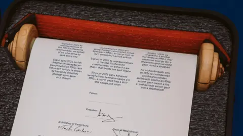 RNLI A scroll of paper on a wooden spindle, carrying a number of signatures. The scroll is contained inside a protective case with a foam lining. 