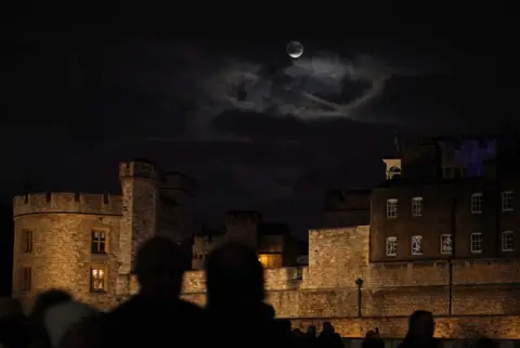 Yui Mok/PA Wire A glimpse of the supermoon done  clouds implicit    the Tower of London.