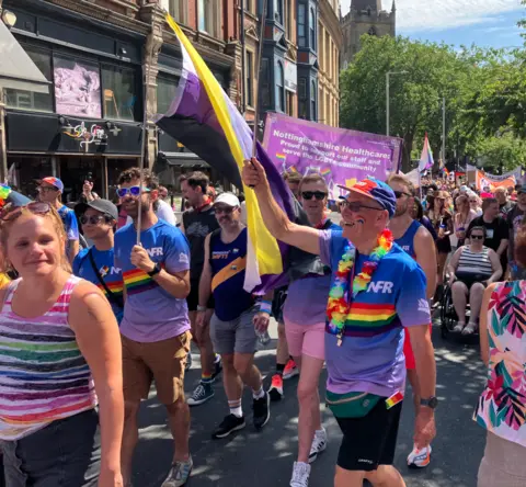 A man proudly waving a colourful flag at Notts Pride in Nottingham city centre on 25 July.