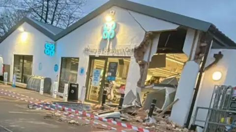 William Browne An exterior view of a Co-op supermarket early in the morning with part of the wall caved in and debris om the ground outside