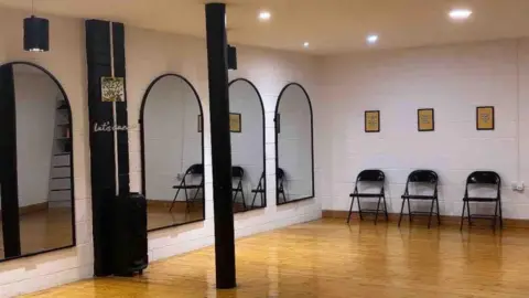 Liv Flanagan Dance studio with wooden floors, mirrors and chairs.