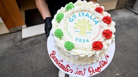 A G7 cake with the words (in Italian) "Welcome to Puglia"
