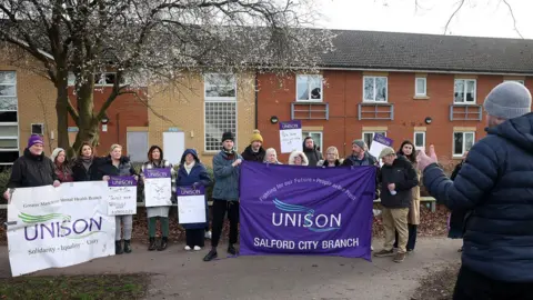 Sean Hansford Protestors hold up UNISON purple and white sign in a demonstration outside the care home