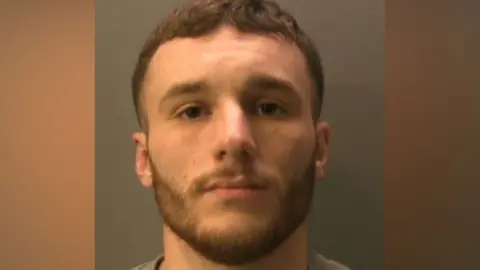 Sussex Police A man with brown hair and dark eyes. 
