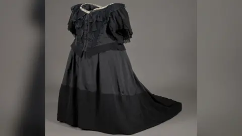 A black, ruffled dress, with short sleeves. 