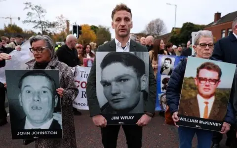 Reuters A crowd gathers in the street holding placards with family members