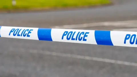 A blue and white striped police tape with the word police written on it in blue lettering