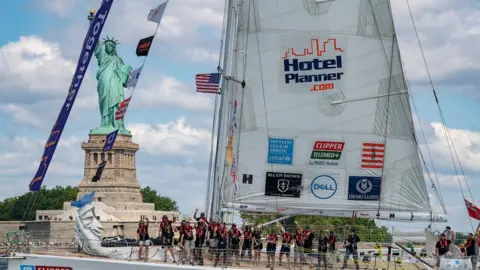 Clipper Round the World Yacht with Statue of Liberty in the background