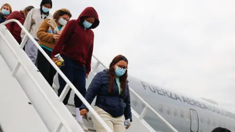 X/@Petrogustavo five women wearing face masks and carrying their passports in their hands coming down from the Colombian Air Force in Bogota