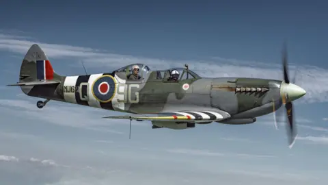 Side view of a Spitfire in the sky with the Royal Airforce emblem on the side.