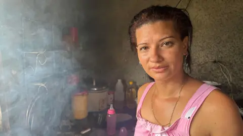 Woman in pink dress looks into camera