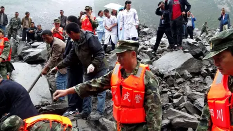 Reuters Rescue workers and medical staff search for survivors at landslide site in Xinmo village in Sichuan, southwest China, 24 June 2017