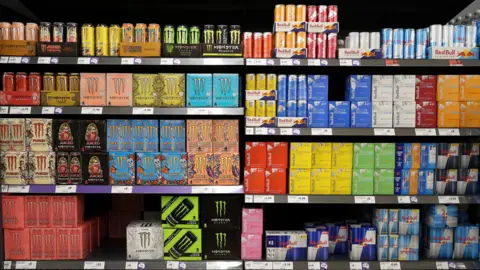 Reuters Brightly coloured Monster, Red Bull and Relentless energy drinks are displayed on supermarket shelves. 