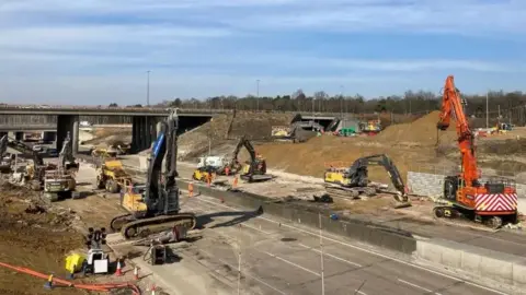 National Highways Construction work taking place on the M25 in Surrey. Pictured are bulldozers and other heavy machinery   