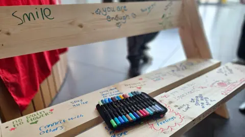 Eastern Education Group A newly built bench signed with messages including Smile and Connect with Others