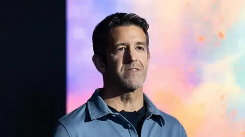 John Ternus wears a blue shirt