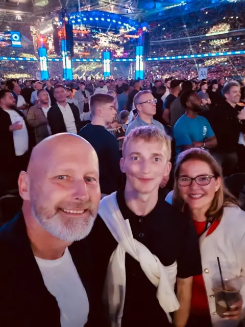 family handout Zane with his dad and stepmother at an event