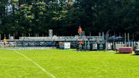 David Murden Workers in hard hats erecting the stage