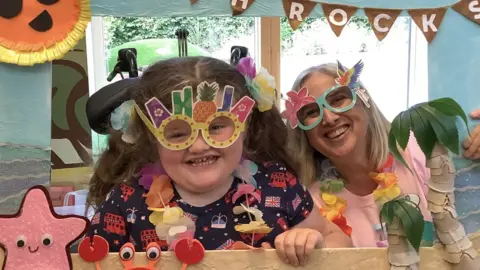 Julia's House Ellie in fun glasses with Julia's House play worker Lisa Magill at the 'JH Rocks' festival