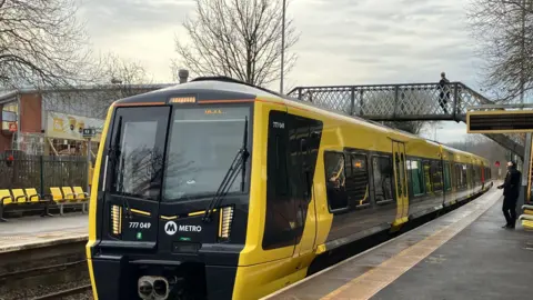 A Merseyrail train at a platform 