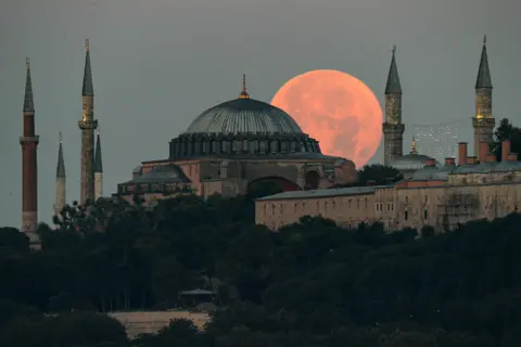 Ali Atmaca / Anadolu Agency / Getty Images Full moon rises over the Hagia Sophia Grand Mosque and Blue Mosque in Istanbul on 14 July 2022.