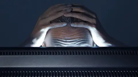 Getty Images A stock image of a person staring in frustration at a computer monitor