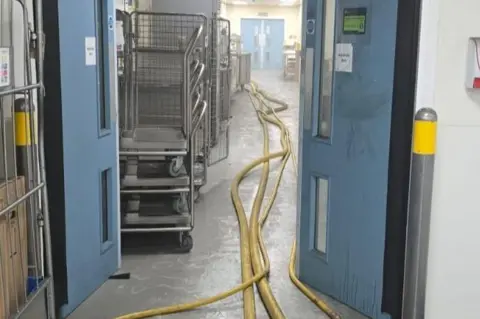 Leicestershire Fire and Rescue Service Hoses running down a murky hospital corridor
