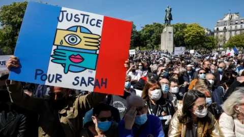 AFP A man holds a placard reading "Justice for Sarah" as people gather to ask justice for late Sarah Halimi on Trocadero plaza in Paris on April 25, 2021