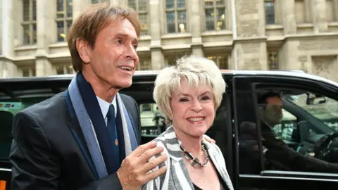 PA Sir Cliff Richard arriving at the High Court on 13 April 2018 with Gloria Hunniford