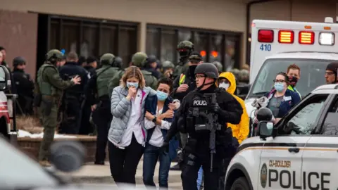 Getty Images Healthcare workers walk out of a King Sooper's Grocery store after a gunman opened fire on 22 March 2021 in Boulder, Colorado